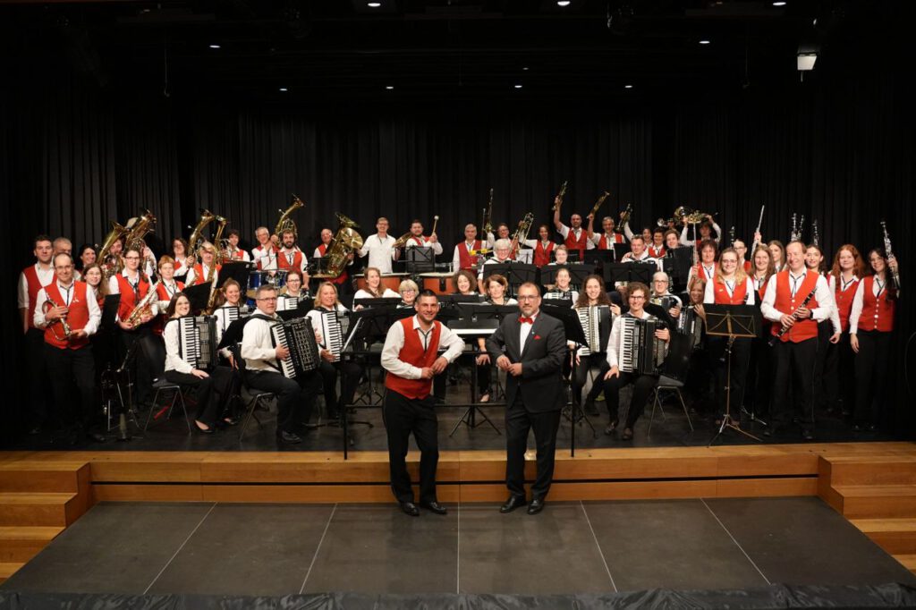 Gruppenbild mit dem Musikverein Nesselwangen und den Harmonika-Freunden Owingen. Viele Personen halten ihre Instrumente in die Höhe.