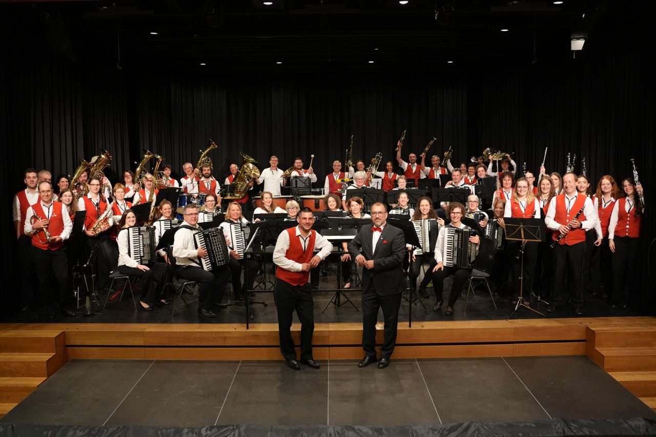Gruppenbild mit dem Musikverein Nesselwangen und den Harmonika-Freunden Owingen. Viele Personen halten ihre Instrumente in die Höhe.